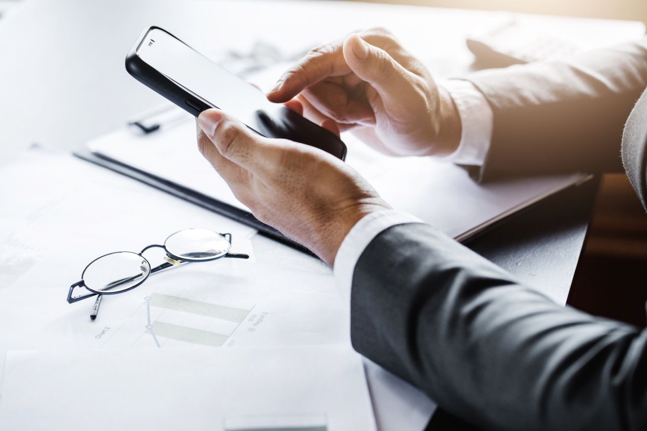 Photographie dite close-up qui fait un focus sur des mains tenant une paire de lunettes, évoquant pour l'occasion une attitude de réflexion introspective